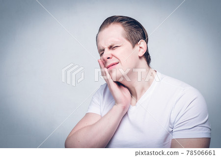 A man massages his jaw from pain - a problem. 78506661