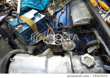 The auto locksmith tightens the valves of the in the garage. The auto locksmith tightens the valves of the in the garage. 78507674