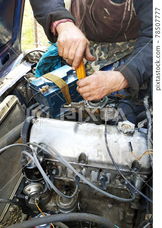 The auto locksmith tightens the valves of the in the garage. The auto locksmith tightens the valves of the in the garage. 78507777