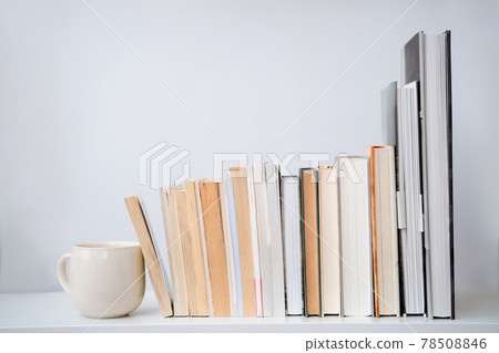 coffee cup tea mug next to a stack of books coffee cup tea mug next to a stack of books 78508846