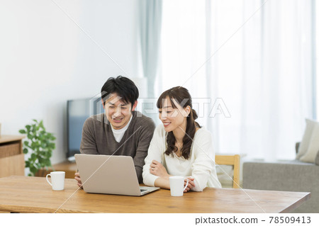 A couple looking at a personal computer 78509413
