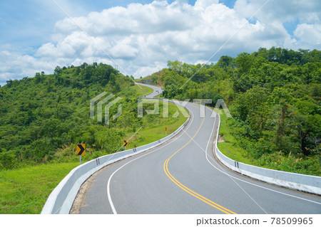 Cars driving on zigzag curve road or street on mountain hill with green natural forest trees in rural area of Nan, Thailand. Transportation. 78509965