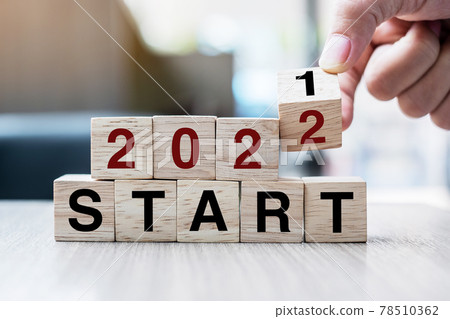 Businessman hand holding wooden cube with flip over block 2021 to 2022 START word on table background. Resolution, strategy, solution, goal, business and New Year holiday concepts Businessman hand holding wooden cube with flip over block 2021 to 2022 START word on table background. Resolution, strategy, solution, goal, business and New Year holiday concepts 78510362