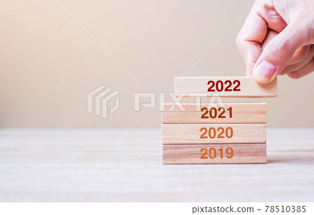 Businessman hand pulling 2022 wooden building blocks on table background. Business planning, Risk Management, Resolution, strategy, solution, goal, New Year New You and happy holiday concepts 78510385