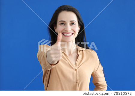 Portrait of smiling businesswoman showing thumbs up gesture 78510572