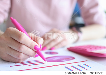 Woman examines business charts with commercial indicators in workplace 78510595