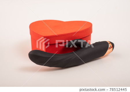 Black dildo and heart-shaped box on a white background Black dildo and heart-shaped box on a white background 78512445