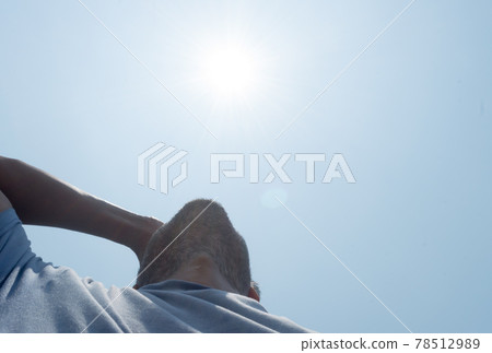 Scorching Hot summer sunlight rays pouring on human head. Hand covering sun light heat temperature. Protection from ultraviolet light and sunburn background. Sunstroke, heatstroke, greenhouse effect. Scorching Hot summer sunlight rays pouring on human head. Hand covering sun light heat temperature. Protection from ultraviolet light and sunburn background. Sunstroke, heatstroke, greenhouse effect. 78512989