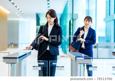 一位女士拿著智慧型手機通過安檢門 攝影合作：LINK FOREST。 78513760