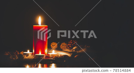 Red Candle with fire against defocused lights in darkness with golden bokeh in the dark Background Red Candle with fire against defocused lights in darkness with golden bokeh in the dark Background 78514884