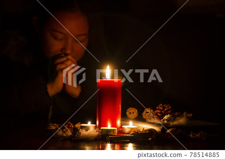 Woman Praying and worship to GOD Using hands to pray in religious beliefs and worship christian with Red Candle with fire against defocused lights in darkness with in the dark Background Woman Praying and worship to GOD Using hands to pray in religious beliefs and worship christian with Red Candle with fire against defocused lights in darkness with in the dark Background 78514885