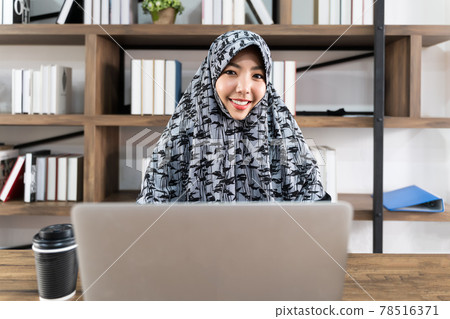 Asian smile Muslim business women are working with laptops while working from home.She participates in video conferences or webinars and works remotely in remote work and work from home concept. 78516371