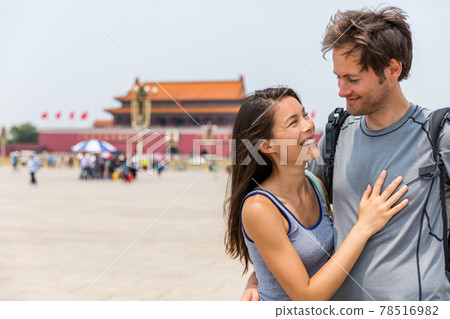 Happy multiracial couple on summer holidays having fun laughing together in love on Tianamen Square, Beijing, china. Asia travel. Chinese woman, Caucasian man, multiethnic tourists 78516982
