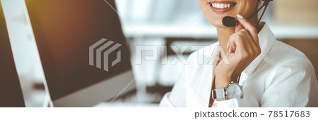 Unknown female customer service representative iconsulting clients online using headset.close-up. Sunny Call center Unknown female customer service representative iconsulting clients online using headset.close-up. Sunny Call center 78517683
