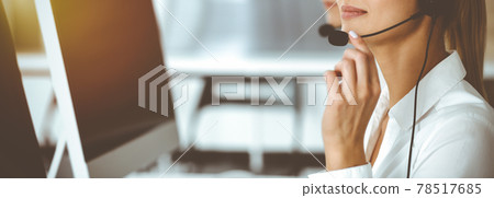 Unknown female customer service representative iconsulting clients online using headset.close-up. Sunny Call center Unknown female customer service representative iconsulting clients online using headset.close-up. Sunny Call center 78517685