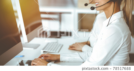 Unknown female customer service representative iconsulting clients online using headset.close-up. Sunny Call center Unknown female customer service representative iconsulting clients online using headset.close-up. Sunny Call center 78517688