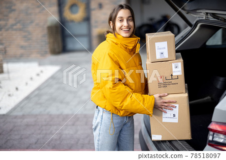Woman arrives home with parcels Woman arrives home with parcels 78518097