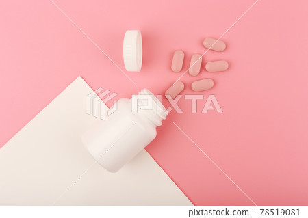 Creative flat lay with nutritional supplement or vitamins for woman. Opened medication bottle on pink background 78519081