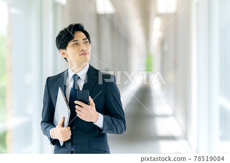 穿著西裝的商人在辦公室拿著智慧型手機 穿著西裝的商人在辦公室拿著智慧型手機 78519084