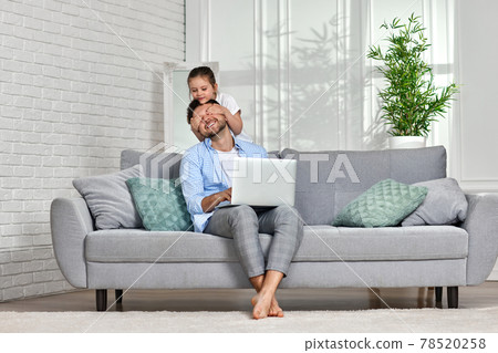 happy little girl hugsher father while he working from home happy little girl hugsher father while he working from home 78520258
