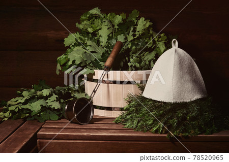 interior of a traditional steam sauna banya with wooden tub, water ladle, hat and bath brooms on a bench 78520965