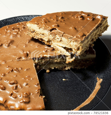 Swedish almond and chocolate cake with a slice cut off, with filling and nuts Swedish almond and chocolate cake with a slice cut off, with filling and nuts 78521836