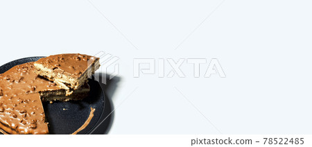 Swedish almond and chocolate cake with a slice cut off, with filling and nuts 78522485