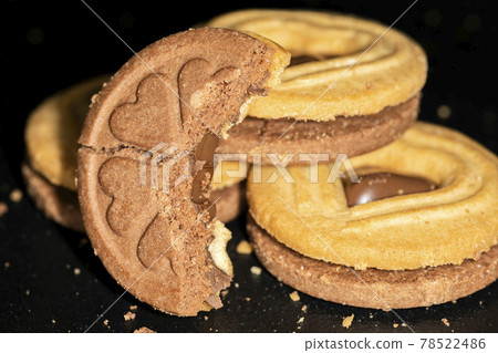 Round chocolate-filled cookies with heart pattern, macro 78522486