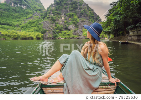Woman tourist in Trang An Scenic Landscape Complex in Ninh Binh Province, Vietnam A UNESCO World Heritage Site. Resumption of tourism in Vietnam after quarantine Coronovirus COVID 19 Woman tourist in Trang An Scenic Landscape Complex in Ninh Binh Province, Vietnam A UNESCO World Heritage Site. Resumption of tourism in Vietnam after quarantine Coronovirus COVID 19 78525630