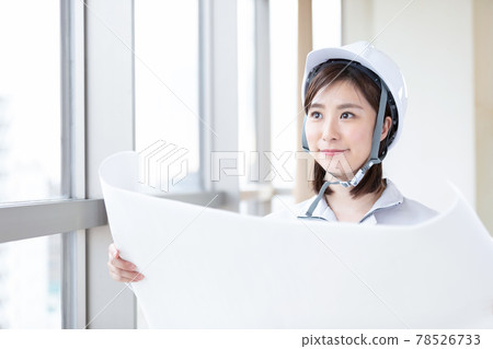 穿著工作服看圖紙的女商人 穿著工作服看圖紙的女商人 78526733