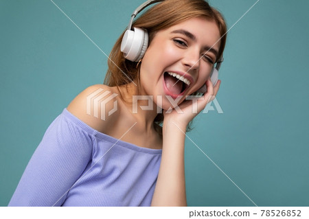 Closeup photo of attractive happy smiling young blonde woman wearing blue crop top isolated over 78526852