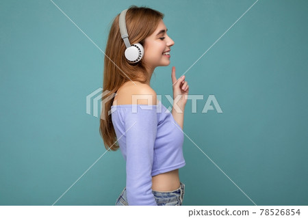 Side-profile photo of beautiful positive smiling young blonde woman wearing blue crop top isolated 78526854