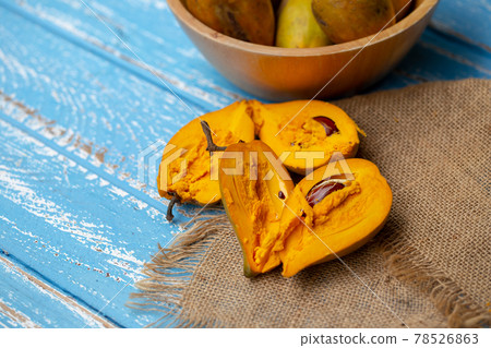 Egg fruit Canistel Yellow Sapote (Pouteria campechiana (Kunth) Baehni) on blue wooden table 78526863