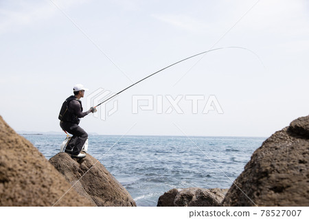 Man fishing on the rocks Man fishing on the rocks 78527007
