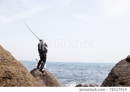 Man fishing on the rocks 78527014