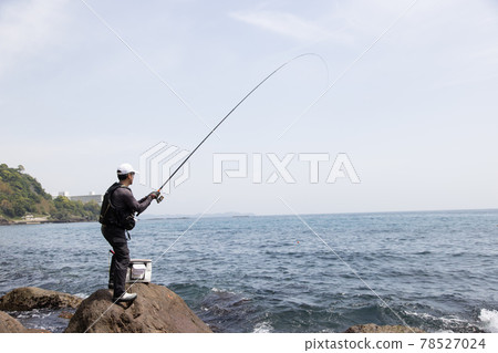 Man fishing on the rocks 78527024