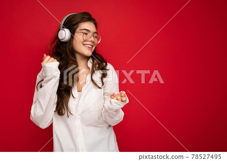 Photo of beautiful happy smiling young brunette woman wearing white shirt and optical glasses 78527495