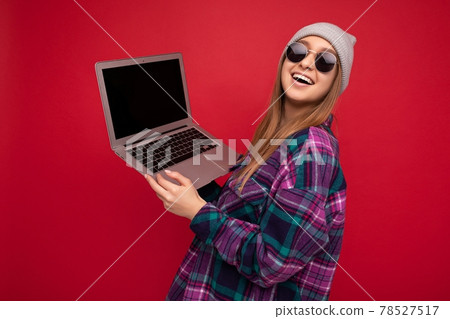 Close-up portrait of Beautiful young woman holding netbook computer looking at camera and happily Close-up portrait of Beautiful young woman holding netbook computer looking at camera and happily 78527517