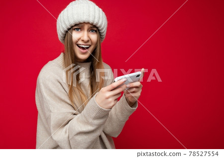 Beautiful emotional happy young blonde woman wearing casual beige sweater and beige hat isolated 78527554