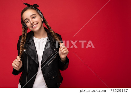 Photo shot of pretty positive smiling brunette little female teenager with pigtails wearing stylish 78529187