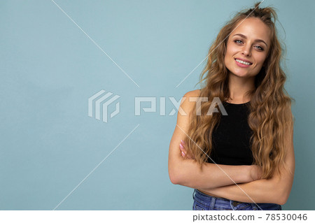 Young beautiful blond woman wearing black top t-shirt looking at camera. Positive female shows Young beautiful blond woman wearing black top t-shirt looking at camera. Positive female shows 78530046