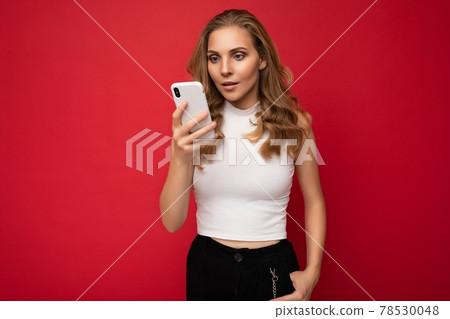 Beautiful young woman wearing casual clothes standing isolated over background surfing on the Beautiful young woman wearing casual clothes standing isolated over background surfing on the 78530048