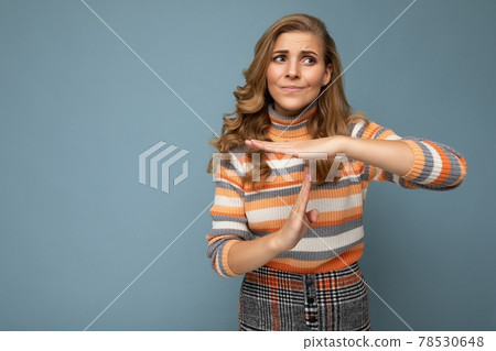 Portrait of sad young beautiful blonde curly woman with sincere emotions wearing stylish striped 78530648