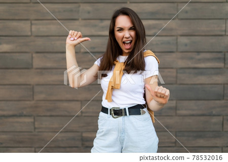 Photo of young happy joyful attractive brunette woman with sincere emotions wearing stylish outfit 78532016