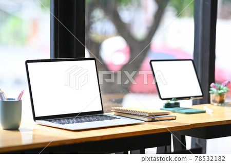 Mock up laptop computer and digital tablet with blank screen on wooden table. Mock up laptop computer and digital tablet with blank screen on wooden table. 78532182