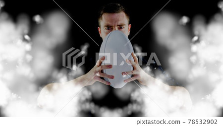 Compostion of caucasian rugby player holding ball on black background with white blur 78532902