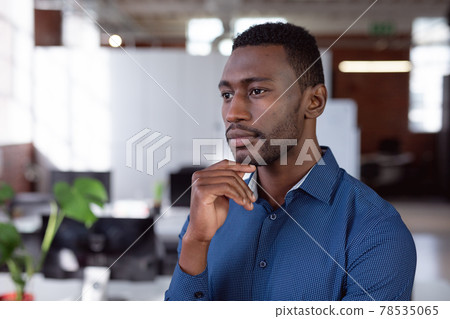 Thoughtful african american businessman standing in office looking away 78535065