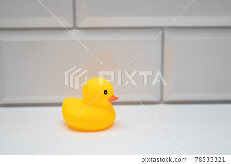 Yellow bath toy duck on a white brick wall in the bathroom Yellow bath toy duck on a white brick wall in the bathroom 78535321