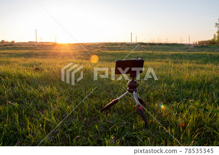 a smartphone on a tripod capturing a sunset in a field a smartphone on a tripod capturing a sunset in a field 78535345