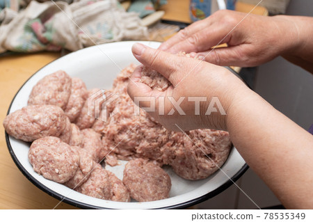 Hands making minced meat cutlets. Preparing meatballs with raw mincemeat Hands making minced meat cutlets. Preparing meatballs with raw mincemeat 78535349